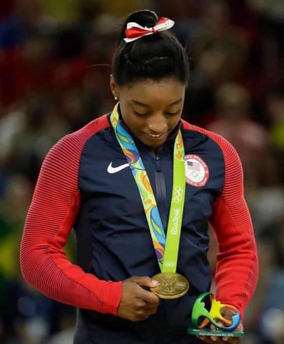 mujer con chamarra y medalla 