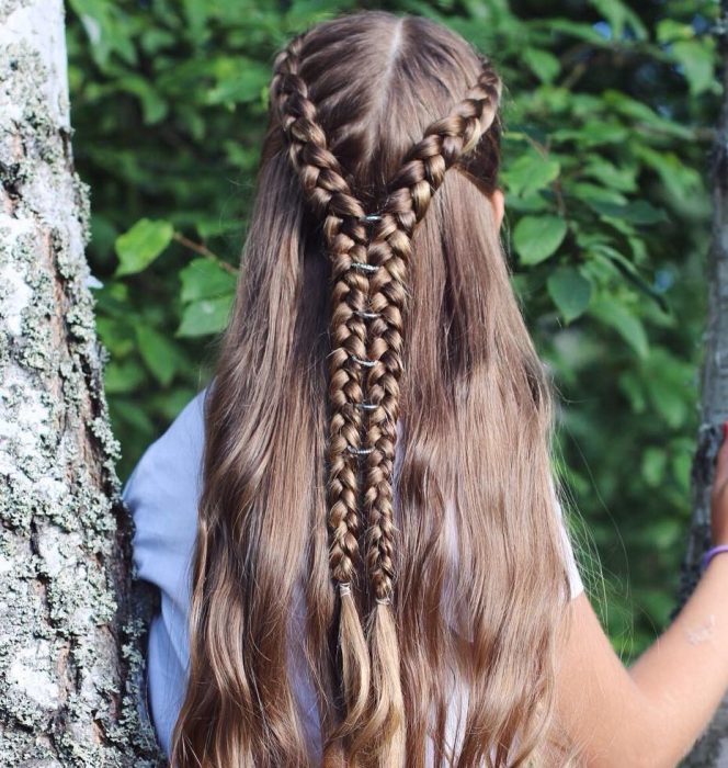 mujer de cabello largo con dos trenzas largas y anillos 