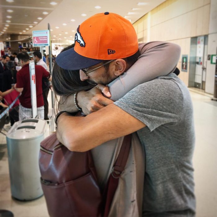 pareja abrazada con gorra en aeropuerto 