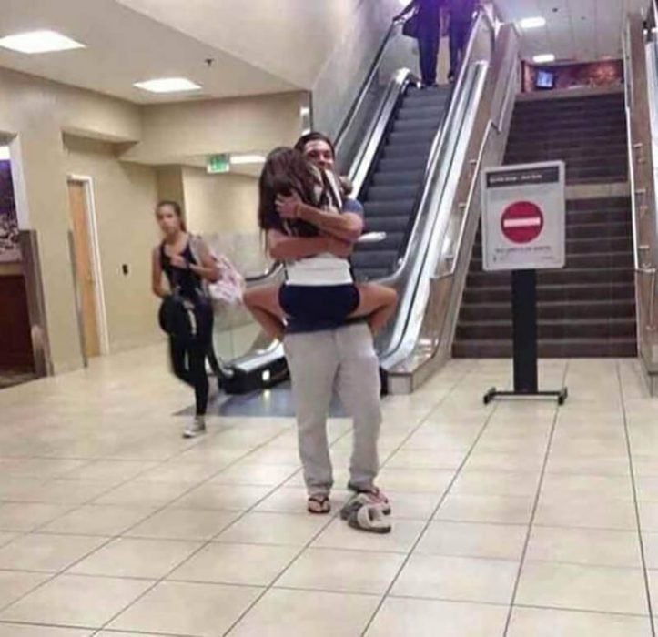 pareja abrazada con gorra en aeropuerto 