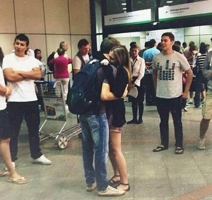 pareja abrazada con gorra en aeropuerto 