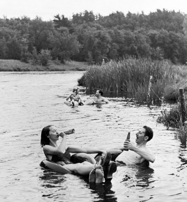 parejas bebiendo y nadando en un río. 