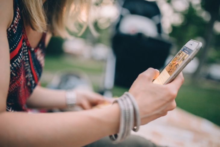 mujer con celular en mano