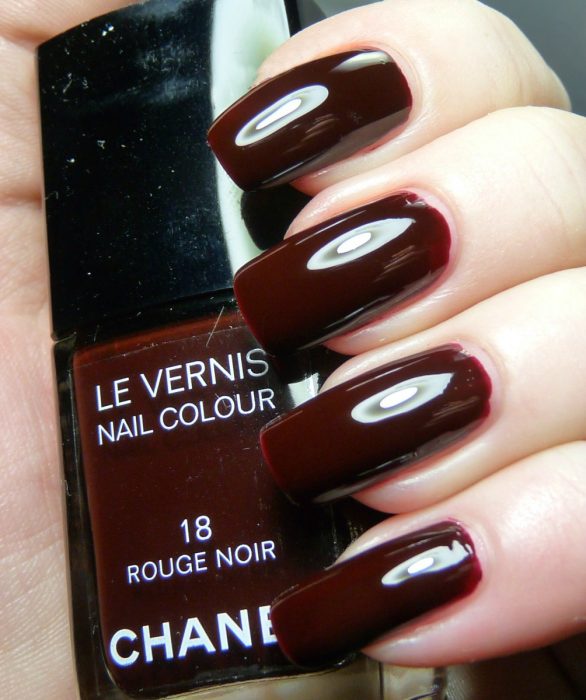 mano con esmalte de color vino chanel 