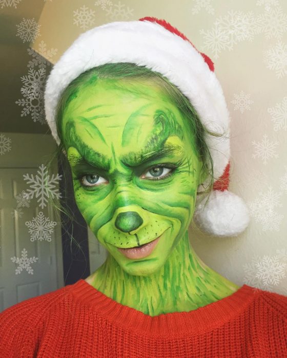 Chica creando maquillaje de fantasía inspirado en el grinch 