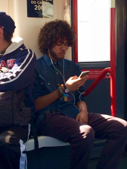 Chico en el metro viendo su celular 