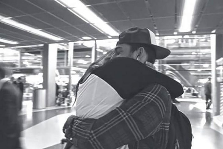 pareja abrazada con gorra en aeropuerto 