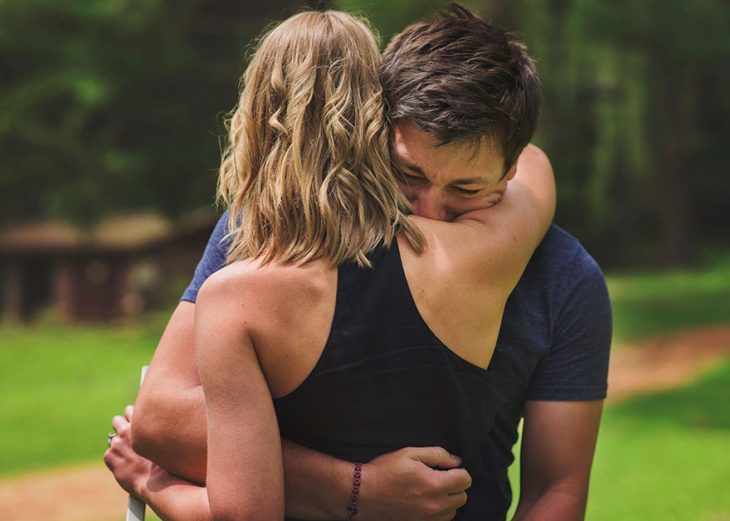 Chico llorando y abrazando a su pareja después de enterarse que será papá en una sesión de fotos sorpresa 