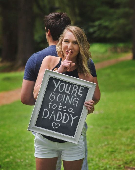 Chica anunciándole a su marido que será papá en una sesión de fotos sorpresa 