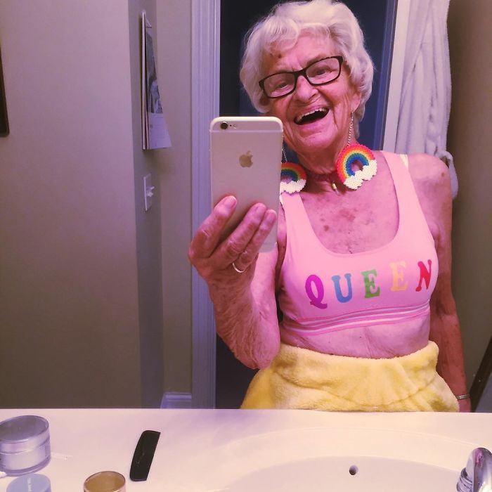 Abuela dbaddiewinkle de 88 años tomándose una foto con su celular mientras está frente al baño 