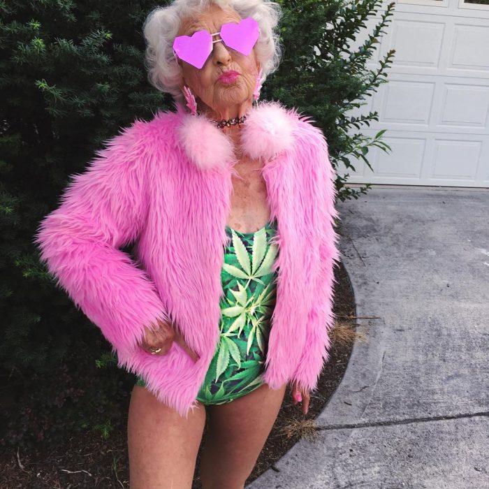 Abuela baddiewinkle de 88 años usando un traje de baño con una chaqueta color rosa y lentes de corazón 