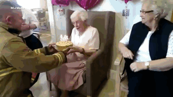 gif bombero entregando pastel a anciana