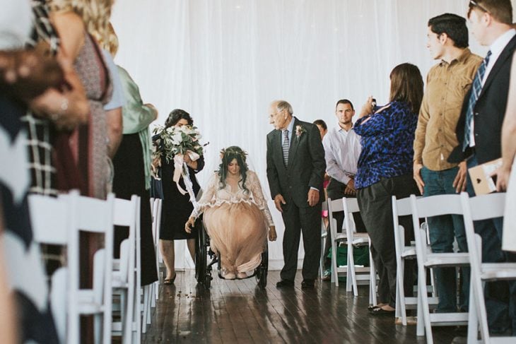 Novia en silla de ruedas yendo hacia el altar el día de su boda 