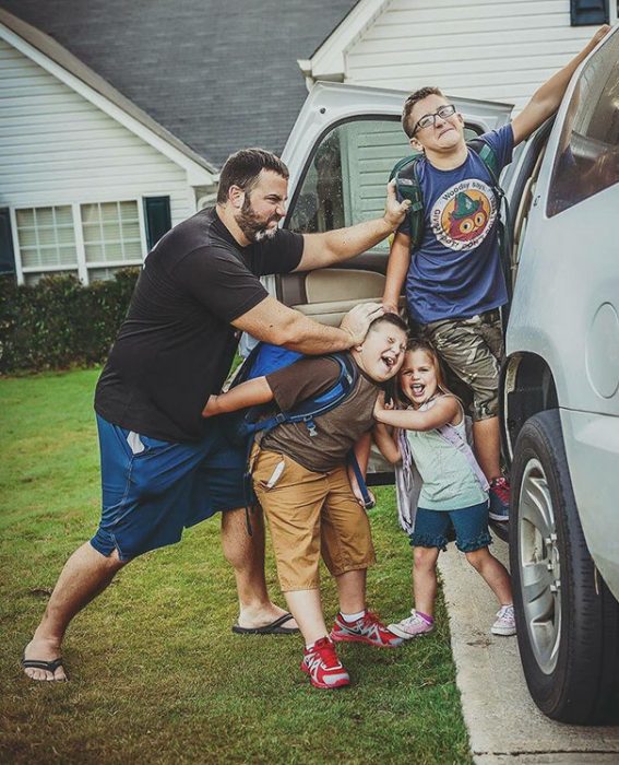 Papá mentiendo a sus hijos a la camioneta para el regreso a clases