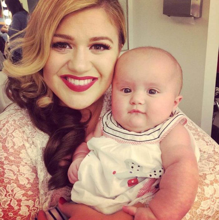 Kelly Clarkson sonriendo junto a su bebé