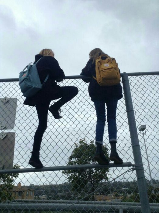 chicas escalando una reja