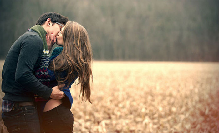 pareja besándose en el campo