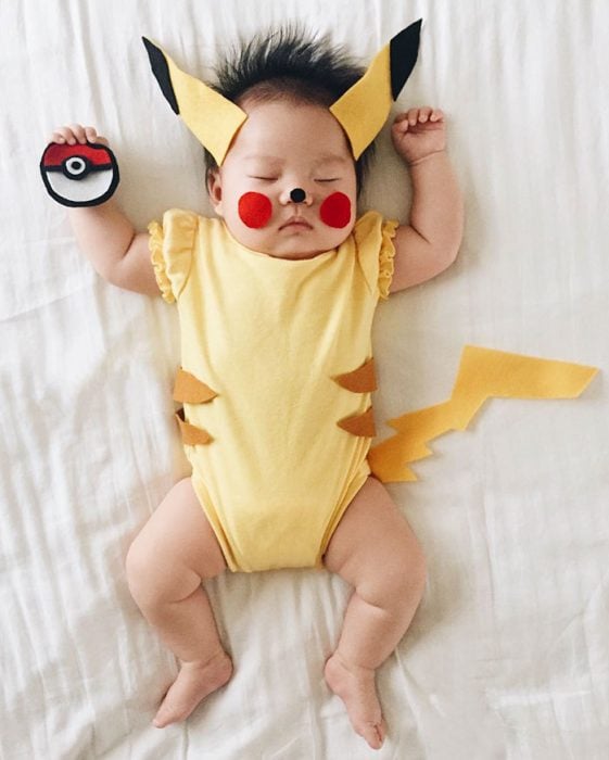 Bebé recostada en la cama disfrazada de pikachú