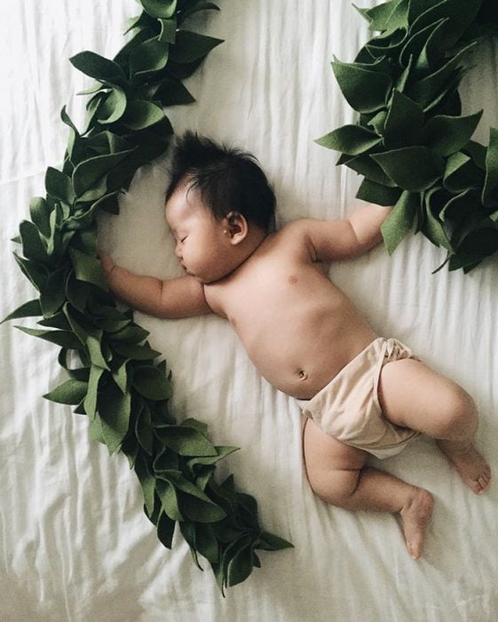 Bebé recostada en la cama disfrazada de tarzan