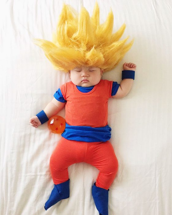 Bebé recostada en la cama disfrazada de goku 