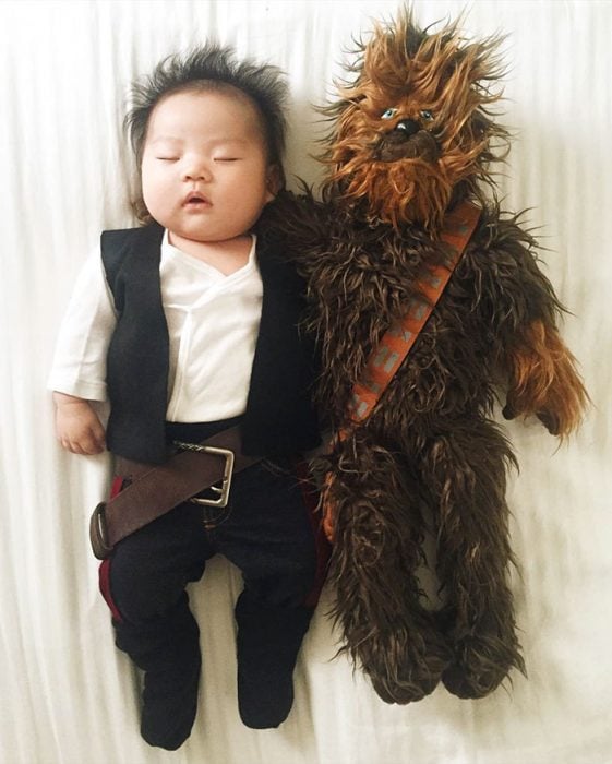 Bebé recostada en la cama disfrazada de Han Solo 