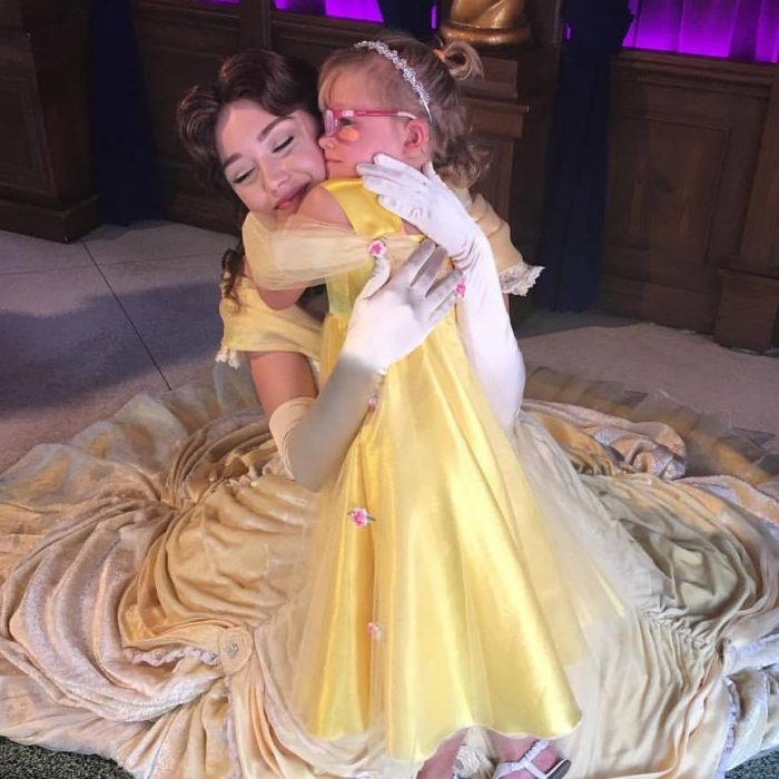 niña disfrazada de bella abraza a Bella en Disney