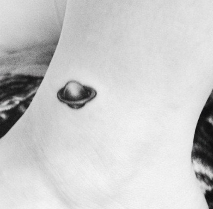 tatuaje de planeta saturno en la mano 