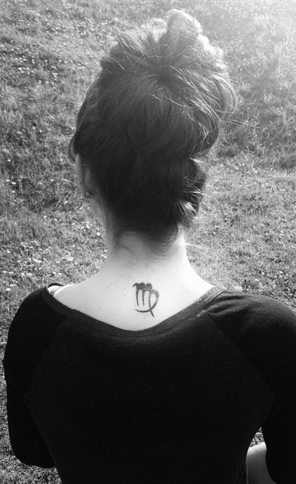 Chica con un tatuaje del signo virgo en su nuca 