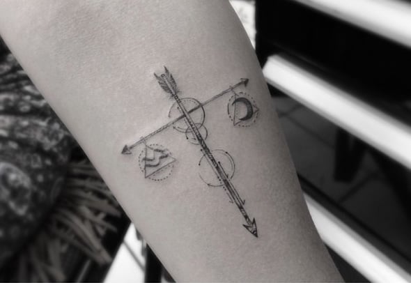 Chica con un tatuaje del signo de libra en su brazo