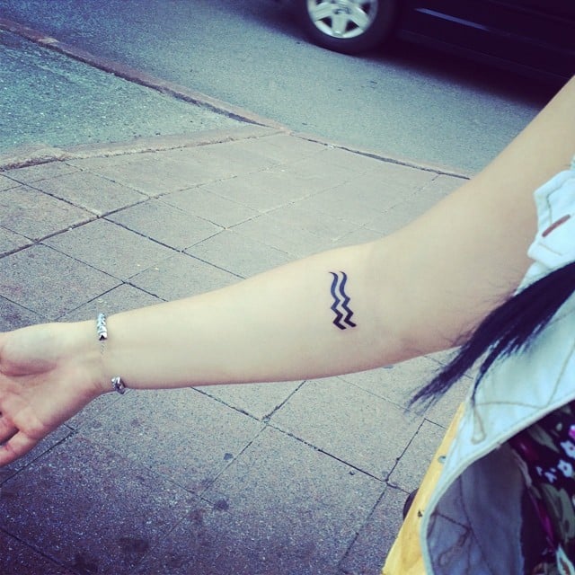 Chica con dos olas tatuadas en el brazo 