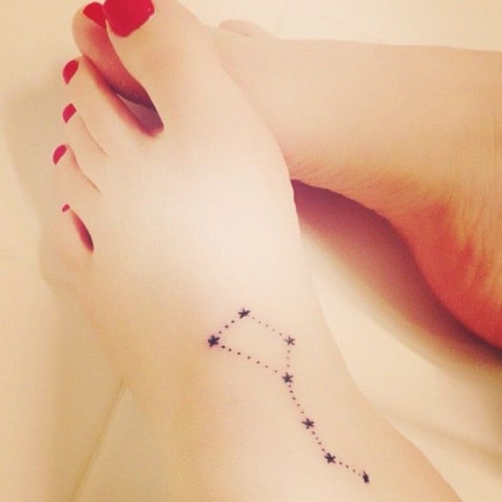 Chica con la constelación de piscis tatuada en el empeine 