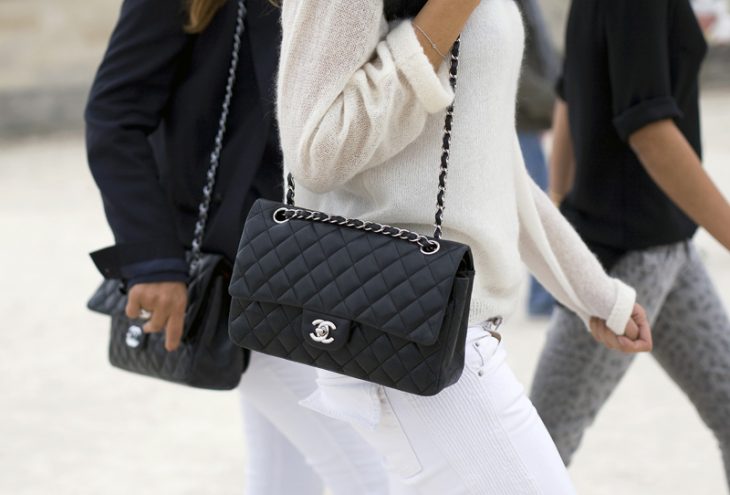 mujer de pantalon blanco con sueter y bolos chanel con correa 