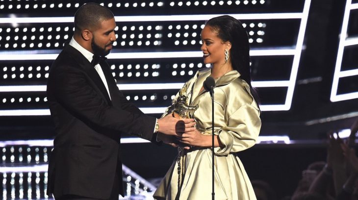 hombre le entrega premio a mujer en escenario vmas 