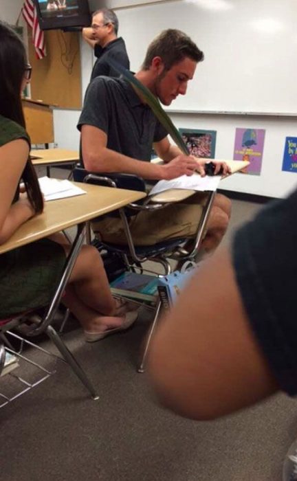 Fotografía de alumno escribiendo con una pluma de ganso. 