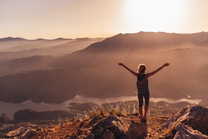 Chica en la montaña con los brazos abiertos 