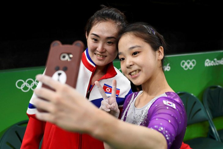 dos mujeres asiaticas sonríen y se toman selfie juntas 