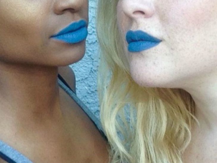 Dos mujeres de piel blanca y morena con labial azul 