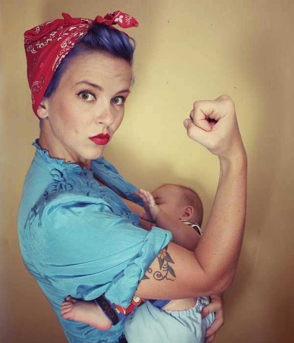 Mujer con estilo vintage amamantando a su bebé. 