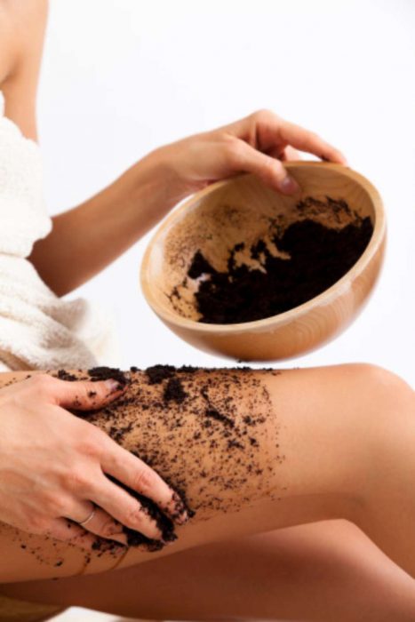 Piernas con un exfoliante de café.