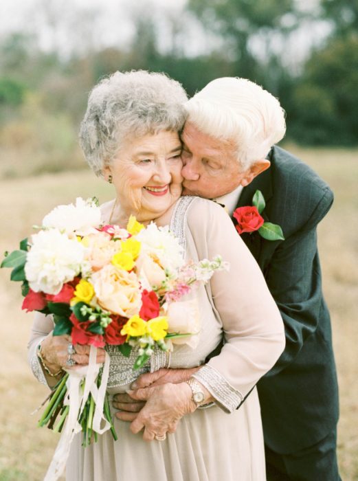 Abuelo besando a la novia en el cachete. 