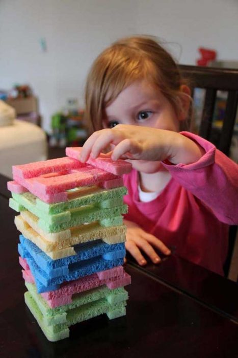 Niña jugando Jenga. 