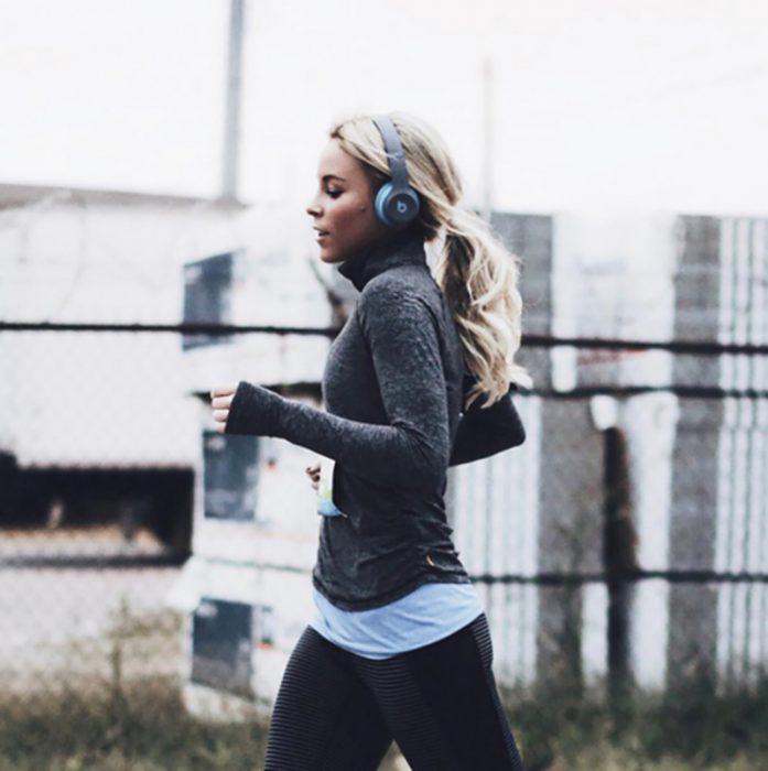 mujer rubia corriendo con audifonos 