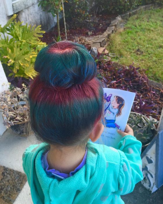 Niña de espaldas con cabello de colores. 