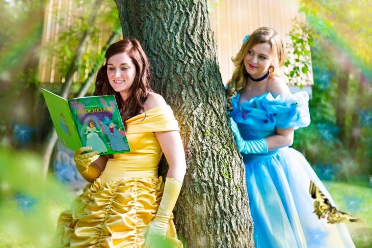 mujers vestidas de princesas con libro de cuentos