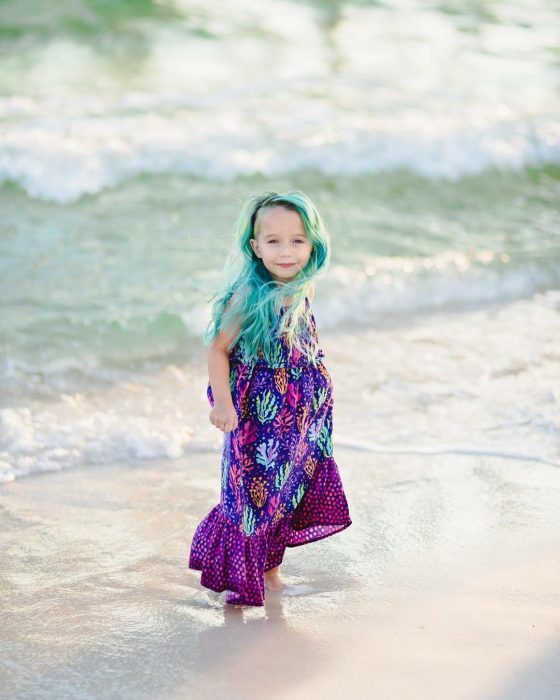 La niña en la playa luciendo su look. 