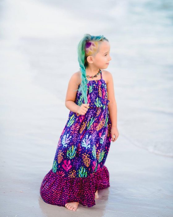 La niña luciendo su look mientras camina por la playa. 