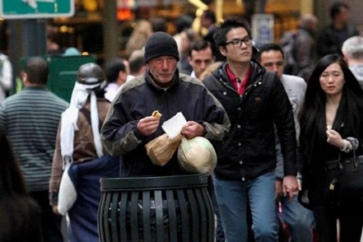 hombre comiendo pizza con bolsas 