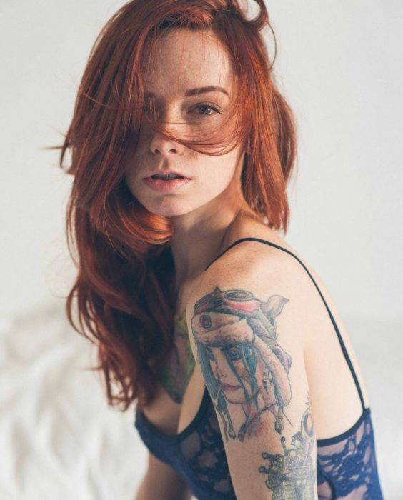 mujer pelirroja con tatuajes 