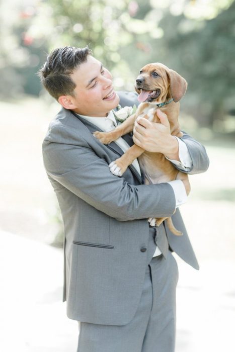 El novio cargando a uno de los perritos. 