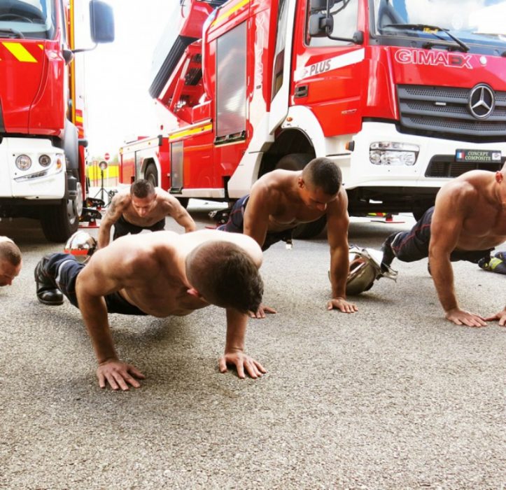 hombres sin playeras haciendo flexiones en el piso 